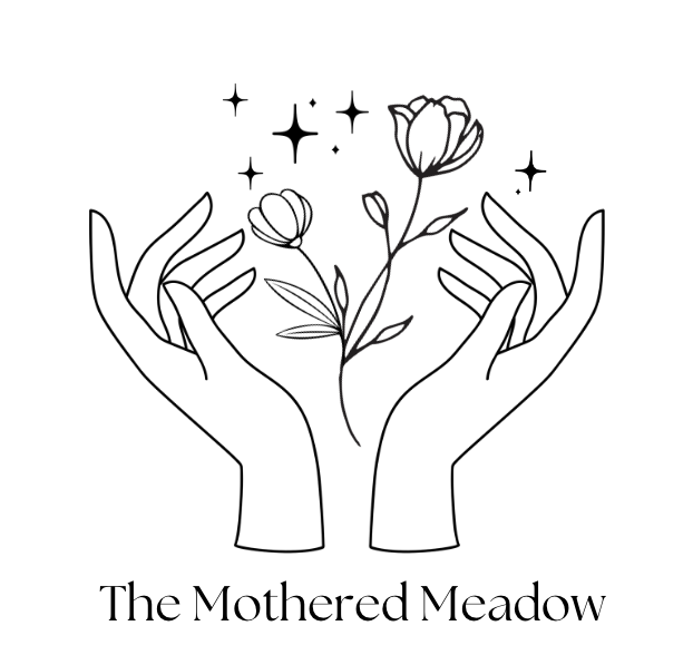 Logo for The Mothered Meadow. Two feminine hands with flowers blooming between them.