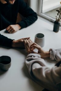 Couple holding hands on a table. Communication with your partner.